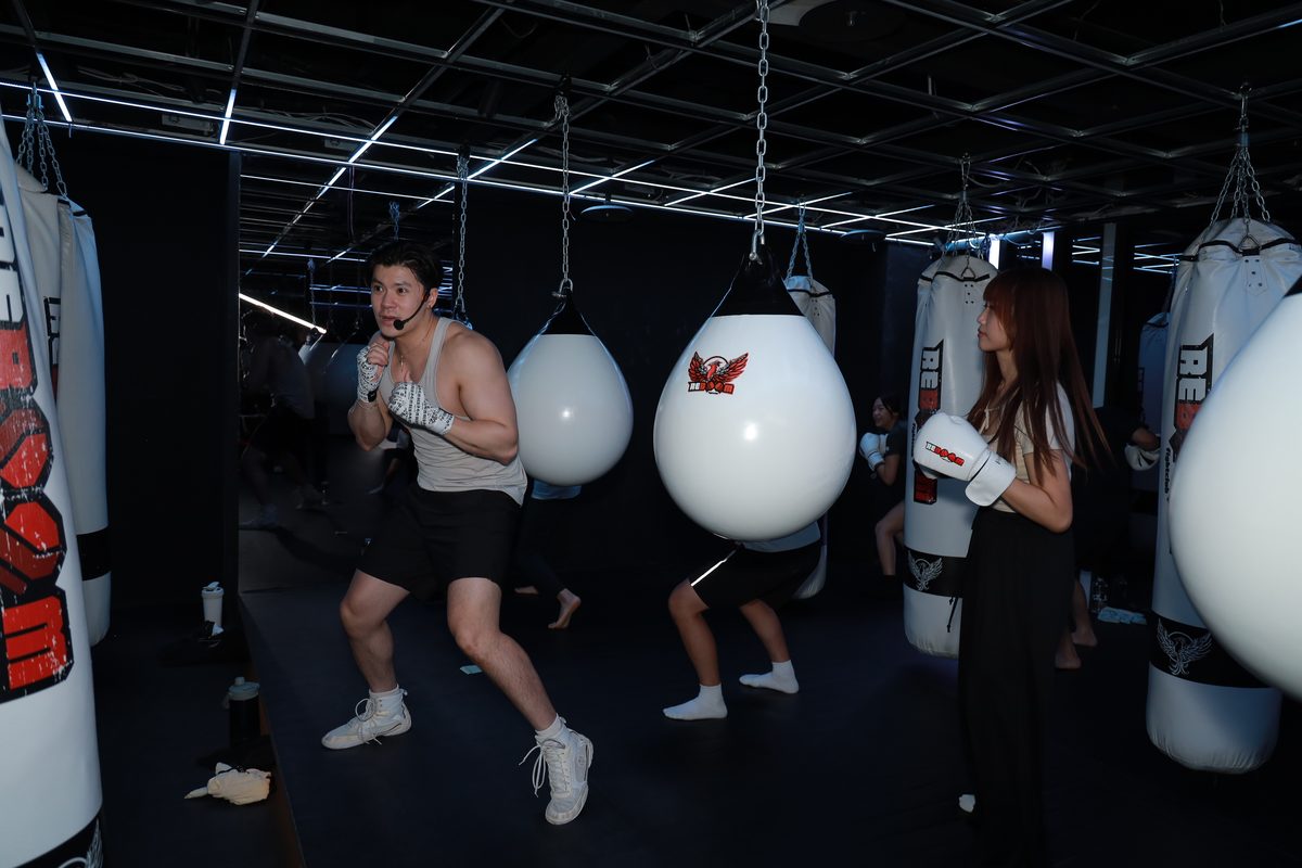 格鬥館裡多位參加者同時對著沙包出拳,場面熱絡